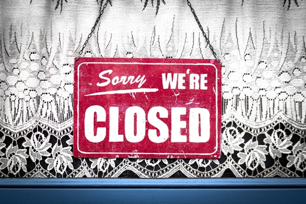 Sorry we're closed sign in the window of a business